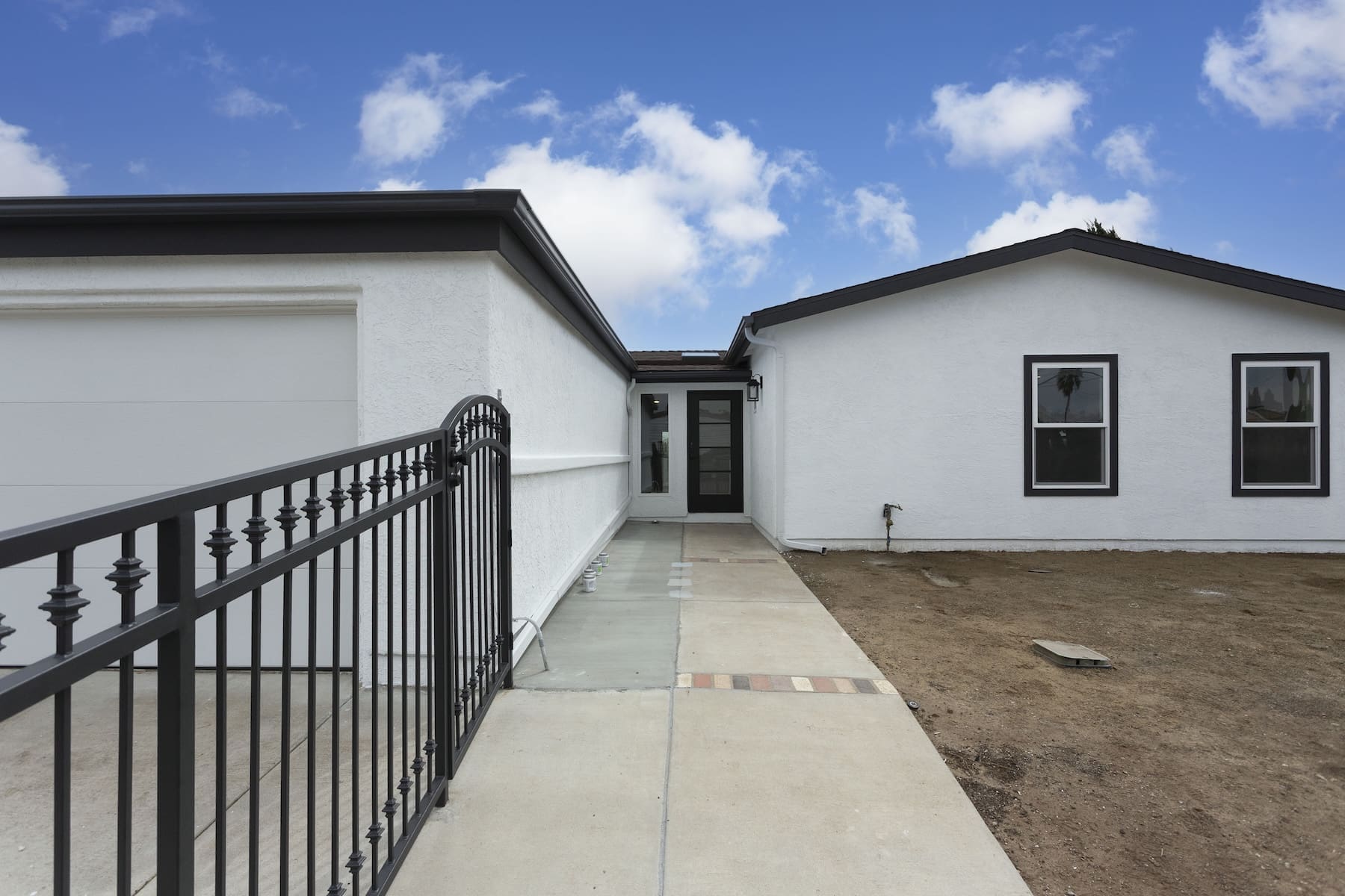 a house with a gate and dirt path